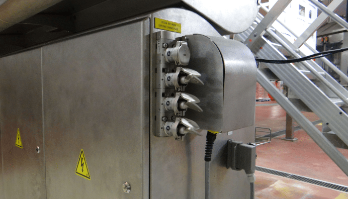 Mechanical trapped key interlock mounted on a bottle blower, washer, and filler in the food and beverage industry.