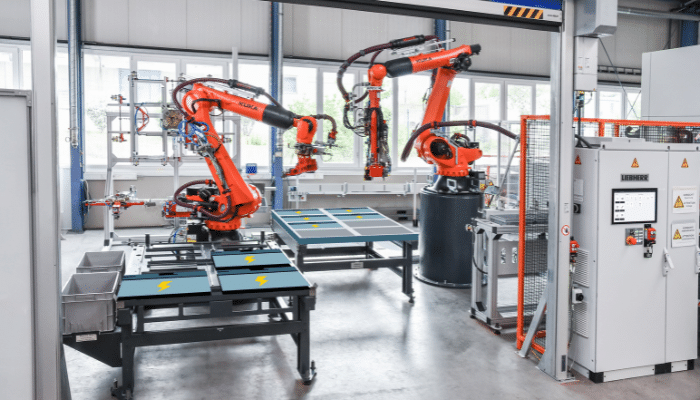 Orange machinery in an EV battery manufacturing facility, illustrating industrial processes and equipment.