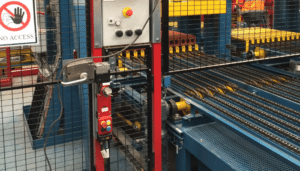 Red amGardpro interlock with a personnel key mounted on a factory gate, illustrating proactive inhibit functions to prevent unexpected start-ups.