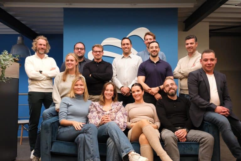 Group photo of Unique Safety Products team gathered in their office, some seated on a sofa.