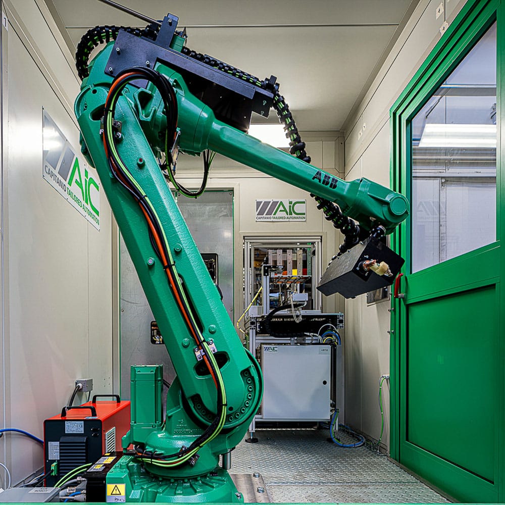 Inside view of large green ABB robot arm behind green guarding with window and amGardpro unit.