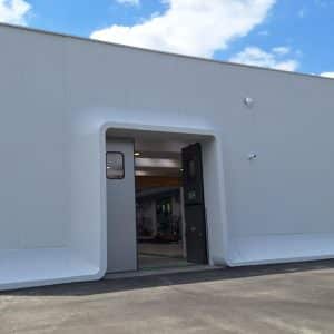 Exterior view of the white AIC facility building in Italy.