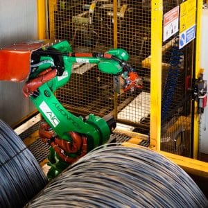 Green robot arm and steel wire bundles inside yellow guarding with Fortress amGardpro interlock.